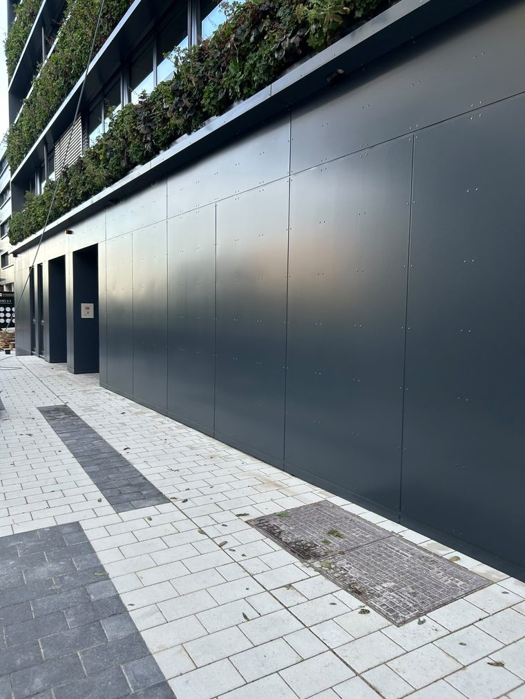 Gereinigte Metallfassade mit anschließender heller Pflasterfläche