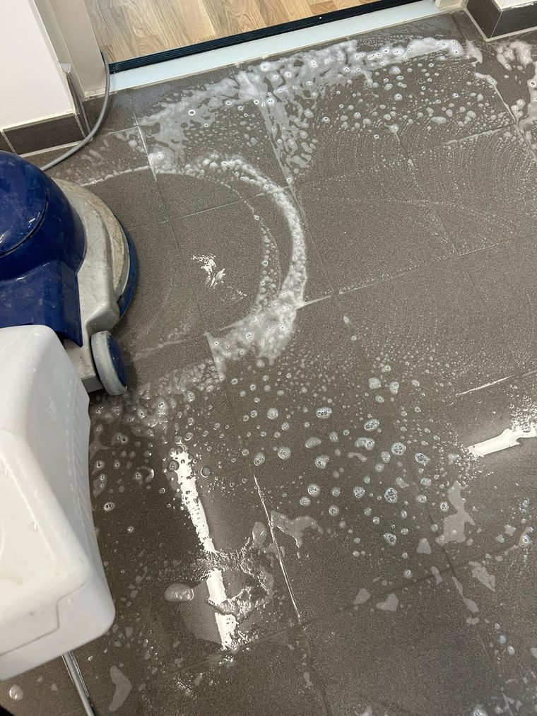 Reinigungsmaschine am Übergang von Fliesenboden zu Parkett an einer Türschwelle