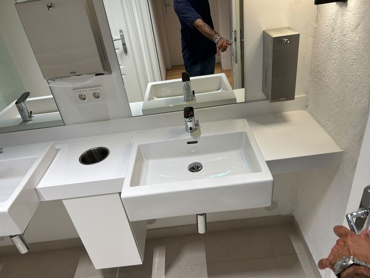 Sanitärraum eines Fitnessstudios mit zwei Waschtischen und Spendern nach der Reinigung