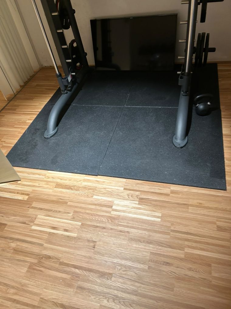 Bodenschutzmatte unter einem Gerät auf dem Parkett eines Fitnessstudios