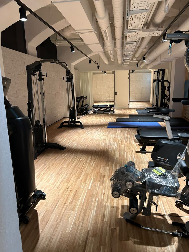 Trainingsfläche eines Fitnessstudios nach der Reinigung, Parkettboden und Geräte