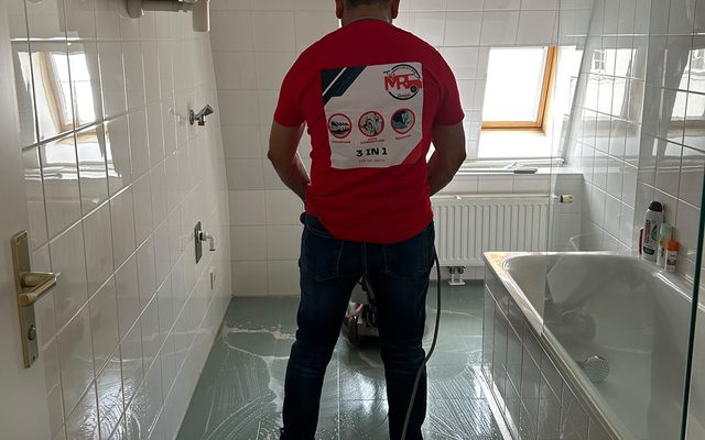 Reinigungskraft reinigt einen Fliesenboden mit der Einscheibenmaschine