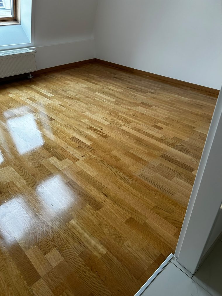 Eichenparkett mit Sockelleiste und Türübergang in einem leeren Zimmer