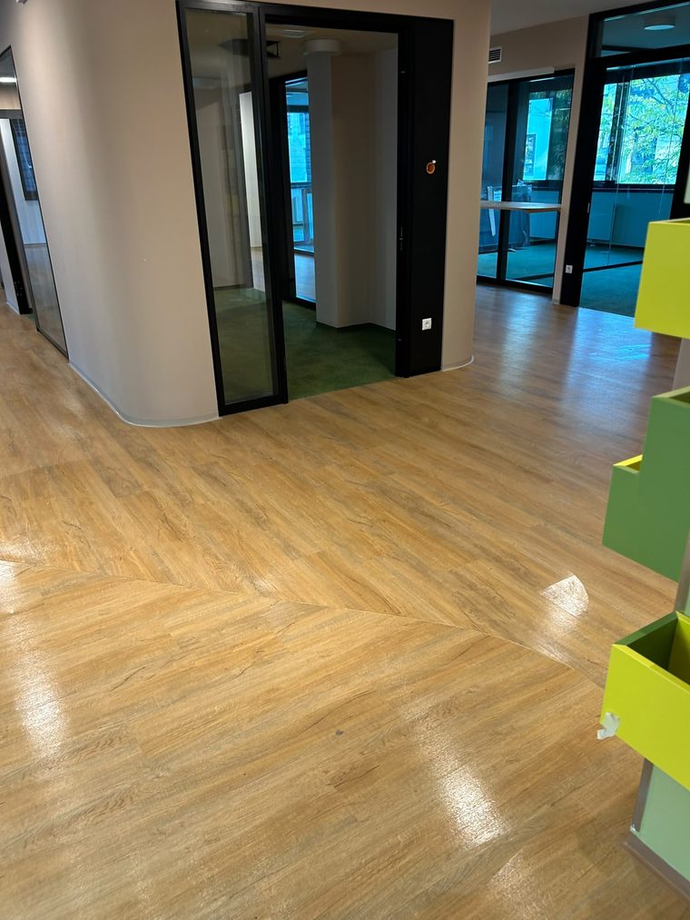Bürofläche mit Bodenbelag in Holzoptik und Glastrennwänden
