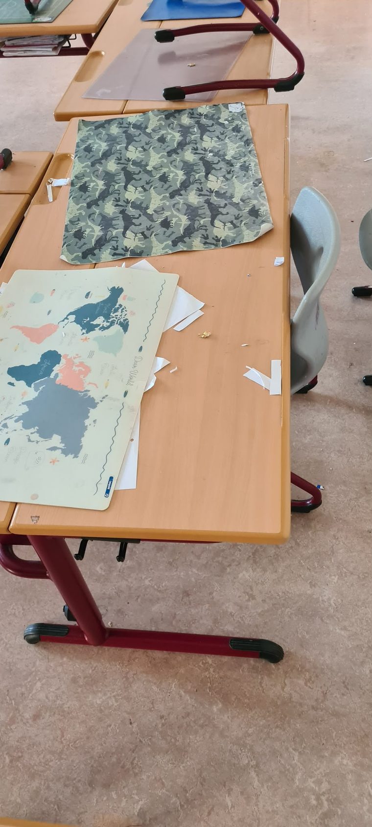 Schultische mit Arbeitsblättern und Unterlagen im Klassenzimmer